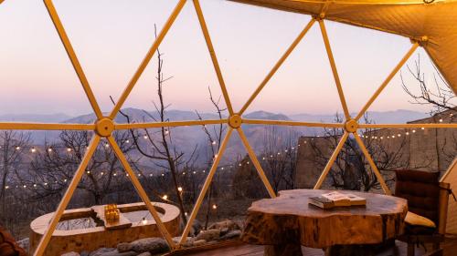 a tent with a table and a view of the mountains at Glamoreo - The Walnut Glamp in Cheog