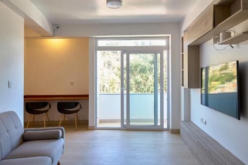 a living room with a couch and a sliding glass door at Maimara Hotel in Huaraz