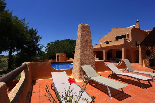 a house with two chairs and a swimming pool at Casa Monte Novo in Lagoa