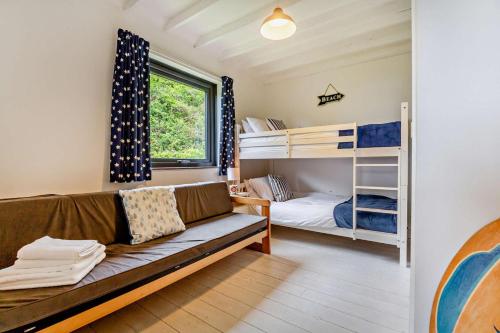 a living room with a couch and bunk beds at Y Grogen in Aberdaron