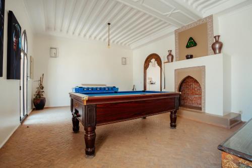 a pool table in a room with a fireplace at DOMAINE DU DOUAR in Marrakech