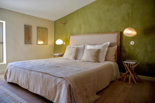 a bedroom with a large bed with green walls at Les Jardins de Sitaara in Cucuron
