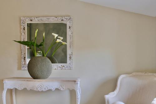 a vase sitting on a table with a mirror at Les Jardins de Sitaara in Cucuron