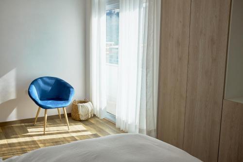 a blue chair sitting in a room with a window at Maimara Hotel in Huaraz