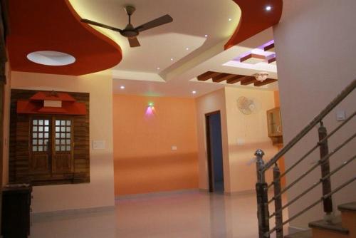 a living room with a ceiling fan and a staircase at Harsharav in Palakkad