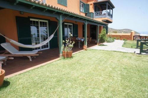 un patio con una hamaca en el lateral de una casa en Profithome - La Palma Sunset Villa, en Puntallana