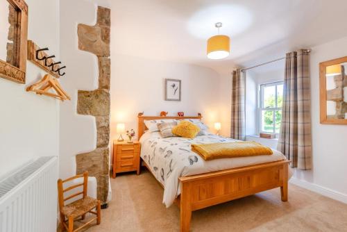 ein Schlafzimmer mit einem Bett und einem Stuhl in der Unterkunft Archway Cottage - Caldbeck in Caldbeck