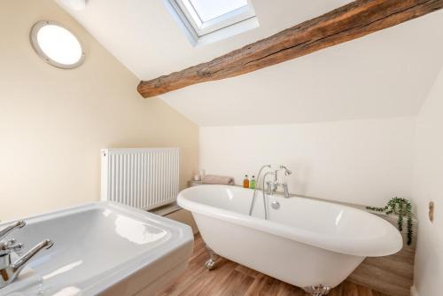 ein Badezimmer mit einer weißen Badewanne und einem Dachfenster in der Unterkunft Archway Cottage - Caldbeck in Caldbeck