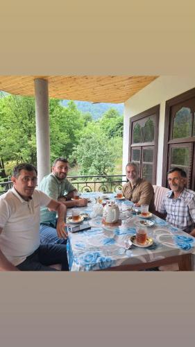 a group of men sitting around a table at Sim Guesthouse in Sım