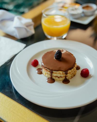 a plate with a pancake with chocolate and berries on it at DOMAINE DU DOUAR in Marrakech
