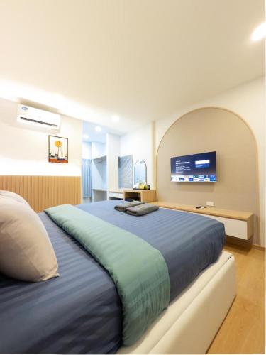 a bedroom with a large bed with a tv on the wall at Tiamo Kohlarn in Ko Larn