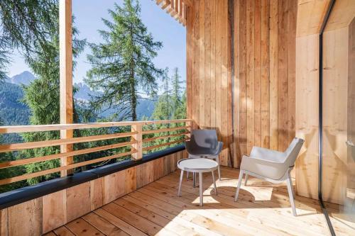 a room with a balcony with two chairs and a table at Munt Dolomiti Farm in Plancios