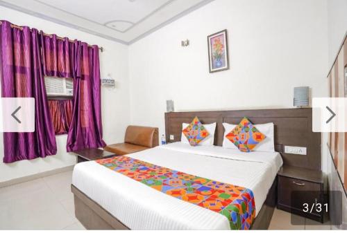 a bedroom with a large bed with purple curtains at Hotel Prashant Palace in Agra