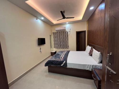 a bedroom with a bed and a ceiling fan at Hotel Shiv Kashi in Varanasi