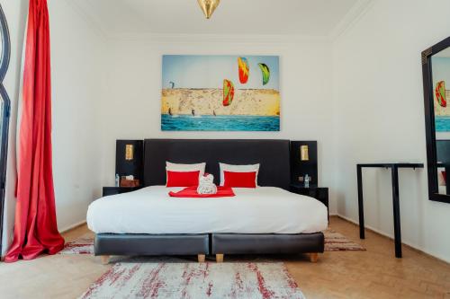 a bedroom with a large bed with red pillows at DOMAINE DU DOUAR in Marrakech