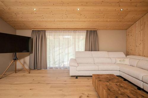 a living room with a white couch and a flat screen tv at Munt Dolomiti Farm in Plancios