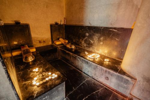 a bathroom with a tub with candles in it at DOMAINE DU DOUAR in Marrakech