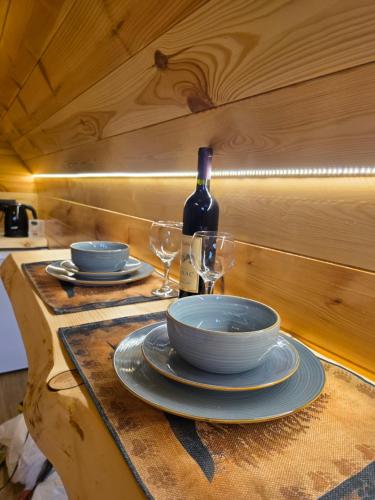 a table with plates and glasses and a bottle of wine at Mountain Peace in Žabljak