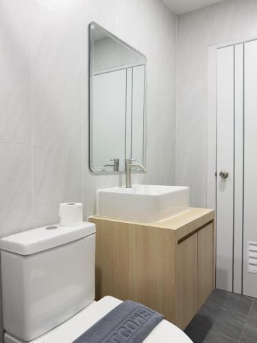 a bathroom with a sink and a toilet and a mirror at Tiamo Kohlarn in Ko Larn