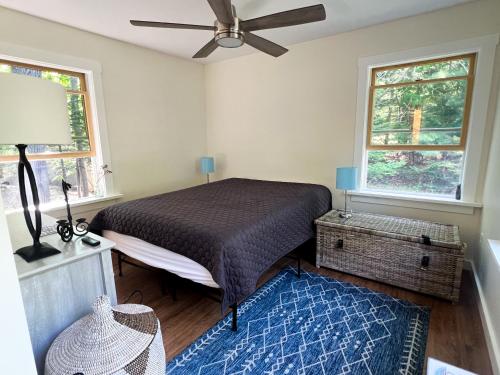 a bedroom with a bed and two windows at Blueberry Cottage in Otter Creek