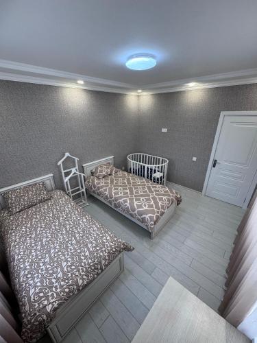 a bedroom with two beds and a crib at Apple Garden Guba in Quba