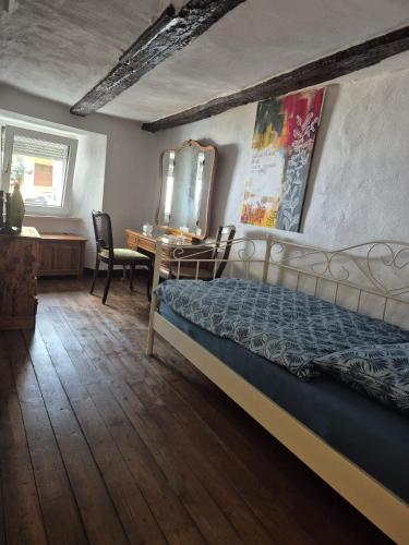 a bedroom with a bed and a desk and a mirror at Haus Tina in Neumagen-Dhron