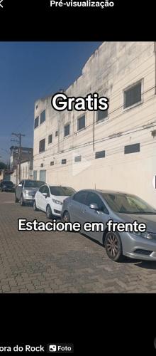 two cars parked in a parking lot in front of a building at Suites Aparecida in Aparecida