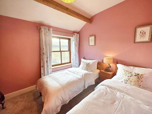 two beds in a room with a window at Low Moor Farm in Cotterdale