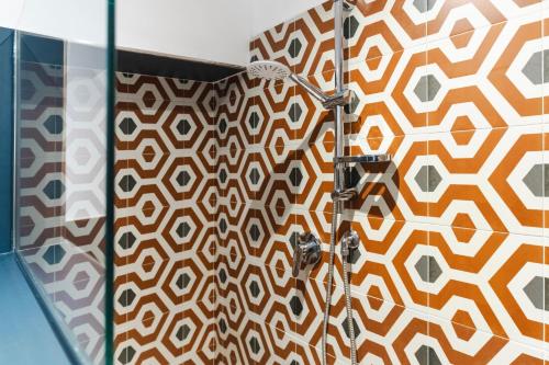y baño con ducha y pared estampada. en Manis Suite Apartment, en Diamante