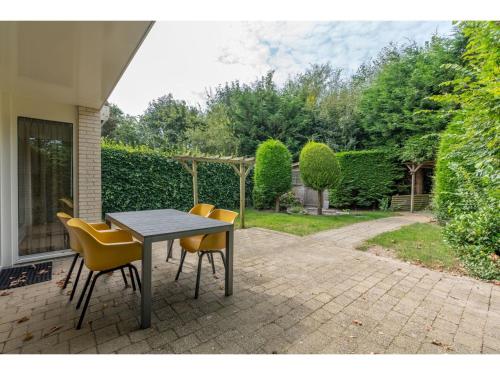 un tavolo e delle sedie seduti su un patio di Island Getaway w Spa Bath a Westermient