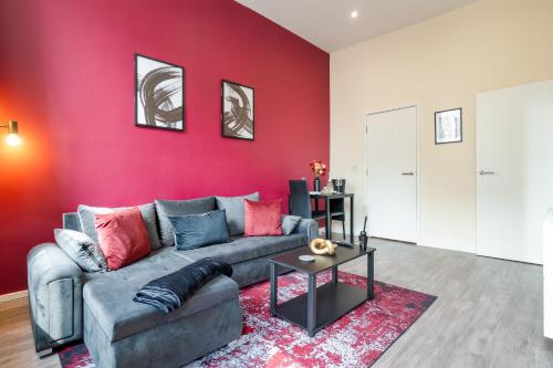 a living room with a couch and a red wall at Prime Location - Modern 1BR in Canterbury Centre in Canterbury