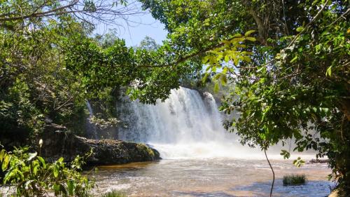 a waterfall in the middle of a river with trees at ibis Styles Rondonopolis in Rondonópolis