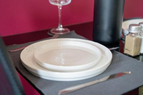 a white plate sitting on a table with a wine glass at Prime Location - Modern 1BR in Canterbury Centre in Canterbury
