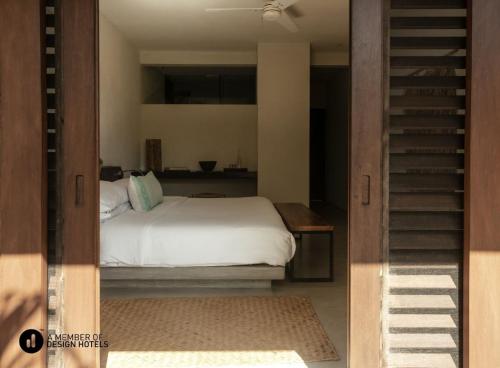 a bedroom with a white bed and a staircase at Lo Sereno Casa de Playa in Troncones