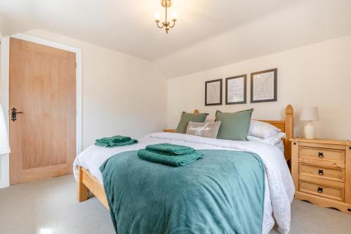 - une chambre avec un lit et des serviettes vertes dans l'établissement No Road - The Cottage, à Bewdley