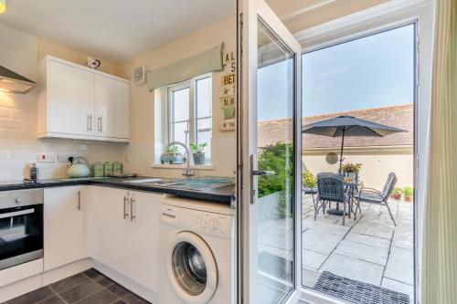 a kitchen with a washer and dryer next to a patio at Bwythyn Y Mor - Broad Haven in Broad Haven
