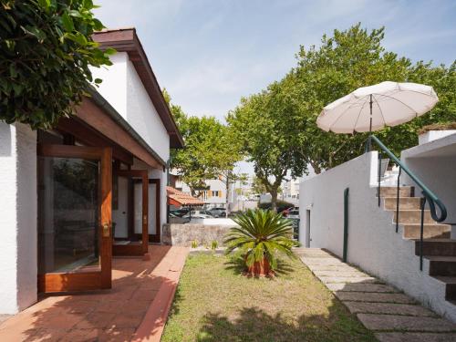 a patio with an umbrella next to a building at Casa d'Abreu Neto - Siza's First Work in Matosinhos