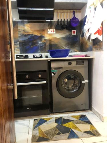 a kitchen with a stove and a washing machine at Peace Dew Apartments in Maiyegun