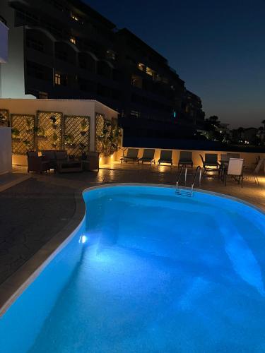a large blue swimming pool at night at White&Blue luxury suites in Ialyssos