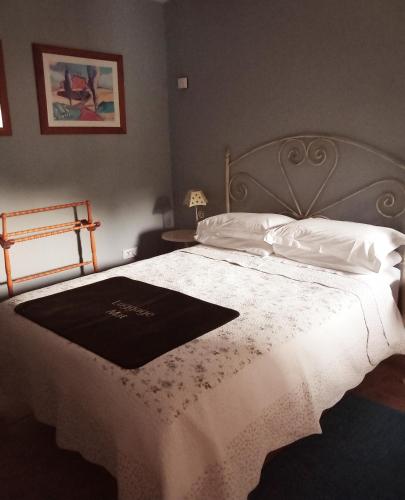 a bedroom with a bed with a black and white blanket at Casa Moya in Alcalá la Real