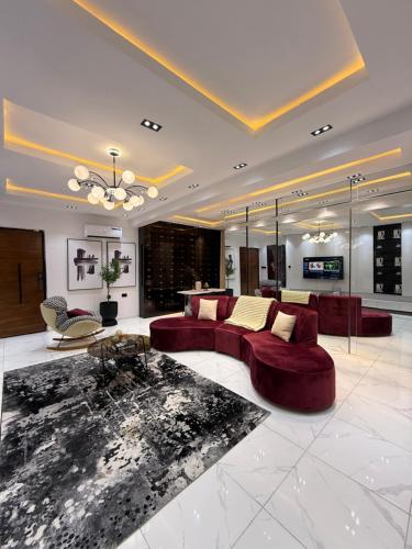 a large living room with red couches and a table at Albert in Lekki