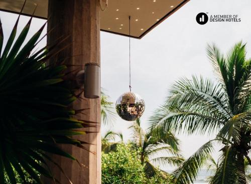a ball hanging from a building with palm trees at Lo Sereno Casa de Playa in Troncones