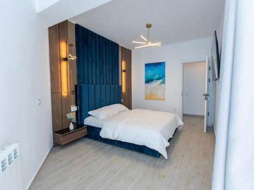 a bedroom with a large bed with a blue wall at Apartament Lara mamaia in Mamaia Nord