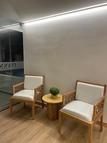 two chairs and a table in a room at Ivanna Jumar ApartaHotel in Medellín