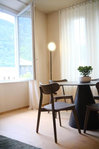 a dining room with a table and chairs and a window at Premier Stay The Balcony - Bernina Experience in Tirano
