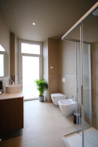 a bathroom with two sinks and a toilet and a shower at Premier Stay The Balcony - Bernina Experience in Tirano