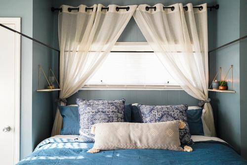 a bed in a bedroom with a window with curtains at King Bed Near Lake w Fire Pit and Pack N Play in Sheboygan
