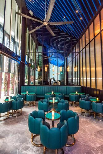 a restaurant with blue chairs and tables in a room at Oasia Hotel Downtown, Singapore by Far East Hospitality in Singapore
