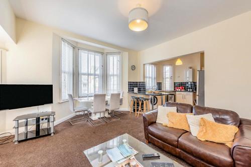 a living room with a couch and a table at Pebble Beach - Bexhill on Sea in Bexhill