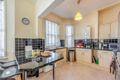 a kitchen with a table with a bowl of fruit on it at Pebble Beach - Bexhill on Sea in Bexhill